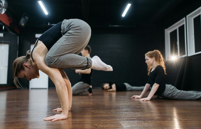 Woman performing a challenging yoga pose, demonstrating flexibility.